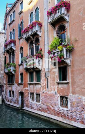 Bâtiment avec jardinières sur les balcons dans un canal étroit, Venise, Italie. Venise est située sur un groupe de 117 petites îles qui sont séparées Banque D'Images