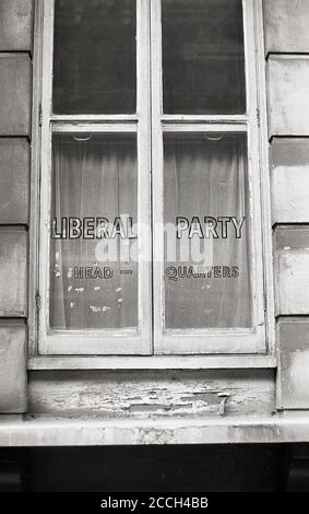 Années 1960, historique, vue extérieure du quartier général du Parti libéral, Victoria, Londres, Angleterre, Royaume-Uni, avec le nom du Parti et les mots Head Quarters entassés dans le verre d'une vieille fenêtre encadrée en bois. Aux XIXe et XXe siècles, le Parti libéral était l'un des deux principaux partis politiques du Royaume-Uni, issus d'une alliance de Whigs, de Peélites et de radicaux libres-échange. Banque D'Images