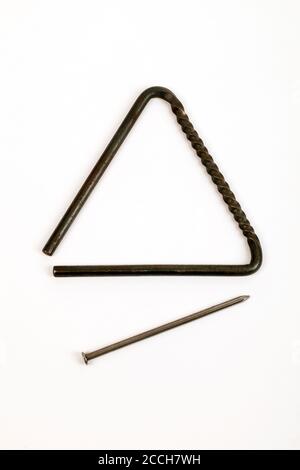 Triangle à structure torsadée pour fournir une surface dentelée pour racler le batteur le long, ainsi que la façon traditionnelle de le jouer. Banque D'Images