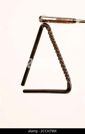 Triangle à structure torsadée pour fournir une surface dentelée pour racler le batteur le long, ainsi que la façon traditionnelle de le jouer. Banque D'Images