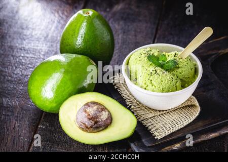 crème glacée à l'avocat faite maison, faite avec des fruits biologiques congelés sans sucre ni lait ajouté. Dessert végétalien. Dessert servi dans un bol en plastique biodégradable. Banque D'Images