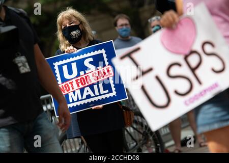 Un manifestant auprès de l'American postal Workers Union (APWU) tient un signe pour protester contre les changements apportés au service postal des États-Unis (USPS) devant l'hôtel Trump International à Washington, DC, le 22 août 2020, dans le contexte de la pandémie du coronavirus. Des dizaines de manifestants avec MoveOn et d'autres groupes se sont rassemblés dans l'ancien bureau de poste, actuellement occupé par l'hôtel Trump International, le même jour, la Présidente Nancy Pelosi, dans un rare mouvement, a rappelé la Chambre des représentants du Sénat du mois d'août pour voter sur la législation des services postaux. (Graeme Sloan/Sipa USA) Banque D'Images