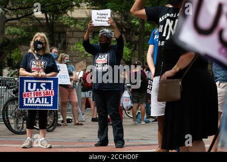 Des manifestants auprès de l'American postal Workers Union (APWU) tiennent des signes pour protester contre les changements apportés au service postal américain (USPS) devant l'hôtel Trump International à Washington, DC, le 22 août 2020, dans le contexte de la pandémie du coronavirus. Des dizaines de manifestants avec MoveOn et d'autres groupes se sont rassemblés dans l'ancien bureau de poste, actuellement occupé par l'hôtel Trump International, le même jour, la Présidente Nancy Pelosi, dans un rare mouvement, a rappelé la Chambre des représentants du Sénat du mois d'août pour voter sur la législation des services postaux. (Graeme Sloan/Sipa USA) Banque D'Images