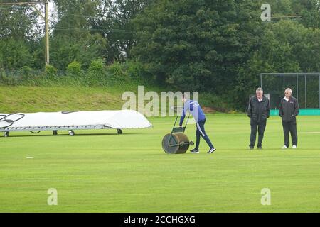 Les arbitres font une inspection du terrain après que la pluie retarde le début du match de la Greater Manchester Cricket League entre Glossop et Denton. Banque D'Images