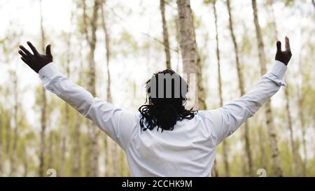Black Lives metters. Homme d'affaires africain avec des mains de l'outstretche priant dans le parc. Photo de haute qualité Banque D'Images