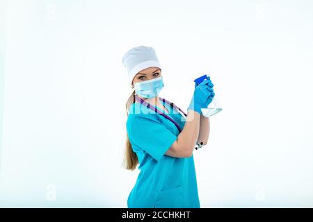 Une femme médecin ou infirmière en uniforme utilise un spray désinfectant. Désinfection. Protection contre les virus et les bactéries. Isolé sur un fond blanc Banque D'Images