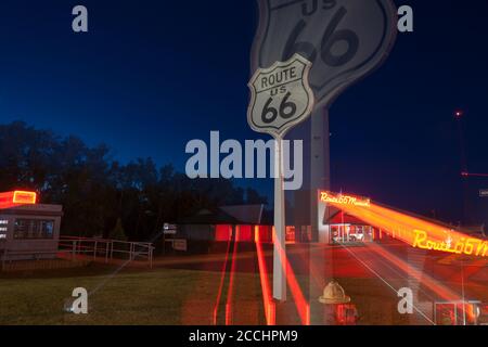 Clinton USA septembre 10 2015; Zoom effet de flou route 66 Musée de style rétro rouge vif et orange panneau néon sur le bâtiment la nuit. Banque D'Images