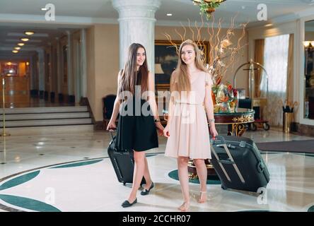 Jeunes filles près de la réception de l'hôtel. Les jeunes filles viennent à l'hôtel. Banque D'Images