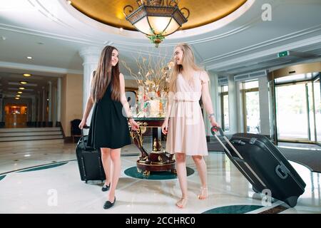 Jeunes filles près de la réception de l'hôtel. Les jeunes filles viennent à l'hôtel. Banque D'Images