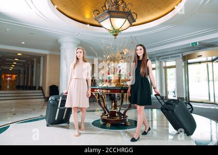 Jeunes filles près de la réception de l'hôtel. Les jeunes filles viennent à l'hôtel. Banque D'Images