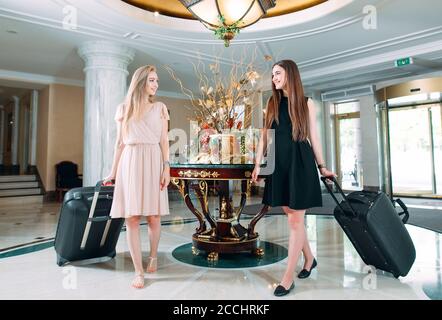 Jeunes filles près de la réception de l'hôtel. Les jeunes filles viennent à l'hôtel. Banque D'Images