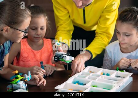 Les enfants créent des robots avec un professeur. Développement précoce, bricolage, innovation, concept de technologie moderne. Banque D'Images