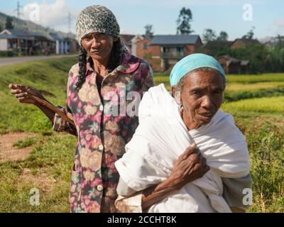 Manandoana, Madagascar - 26 avril 2019 : des femmes malgaches âgées inconnues se tenant à côté du champ de riz où elles ont travaillé le jour ensoleillé. Personnes dans cette partie Banque D'Images