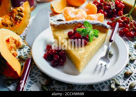 Gâteau de citrouille sucré Halloween avec crème de canneberges et fourchette sur une assiette. Photographie alimentaire Banque D'Images