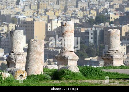 Ruines de colonnes corinthiennes romaines dans la Citadelle d'Amman, Jordanie. Arrière-plan flou et flou montrant les gratte-ciel d'Amman. Banque D'Images