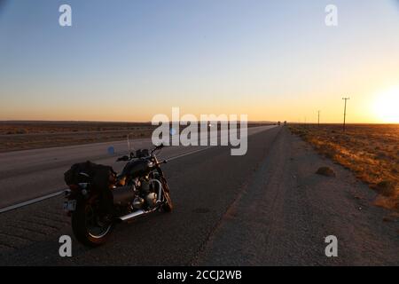 Un Speedmaster 2018 de Bonneville Triumph sur route pendant un coucher de soleil spectaculaire Banque D'Images