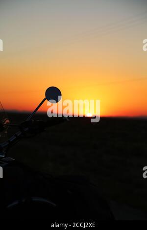 Un Speedmaster 2018 de Bonneville Triumph sur route pendant un coucher de soleil spectaculaire Banque D'Images