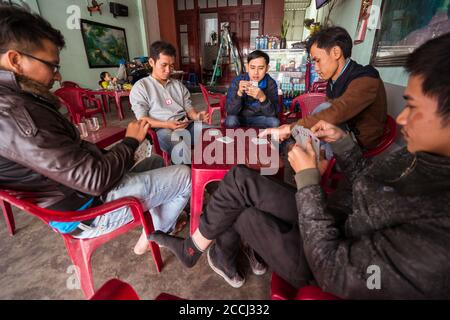 Hoi an / Vietnam - 18 janvier 2020: Groupe de jeunes hommes vietnamiens jouant des cartes à une table Banque D'Images