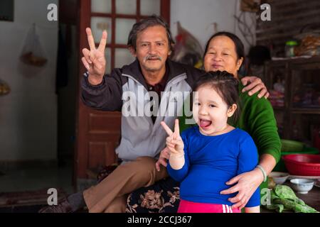 Hoi an / Vietnam - 18 janvier 2020: La famille vietnamienne souriant à la caméra faisant le symbole de la victoire Banque D'Images