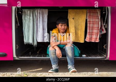 Hoi an / Vietnam - 18 janvier 2020: Portrait de jeunes vietnamiens assis dans le coffre de bus Banque D'Images