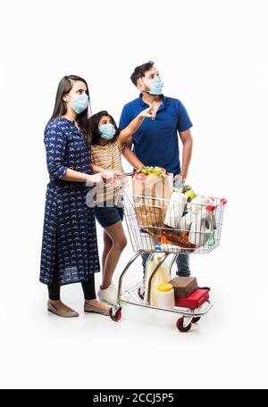 Famille indienne Shopping avec des enfants pendant l'épidémie de virus. Mère, père et fille portant un masque chirurgical achetant une épicerie dans un supermarché. Famille i Banque D'Images