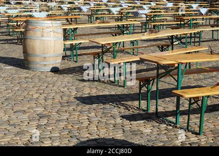 Tables et bancs en bois disposés en rangées sur la place Minster à Fribourg-en-Brisgau, en Allemagne. Certaines tables sont recouvertes d'une nappe bleue. Banque D'Images