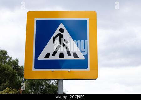 Panneau de signalisation routière pour passage à niveau pour piétons dans un cadre jaune sur un ciel bleu, symbole de passage à niveau sur la rue Banque D'Images