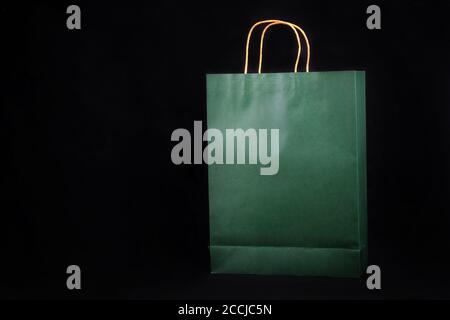 Emballage en sac de papier vert ordinaire sur fond noir Banque D'Images