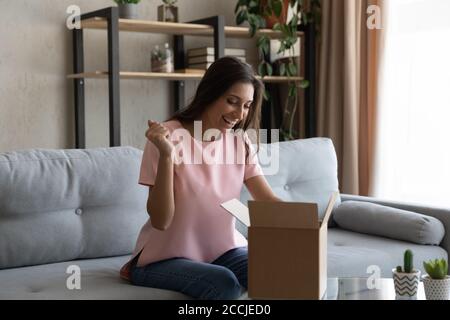 Bonne femme ethnique satisfaite de la livraison de commande par Internet Banque D'Images