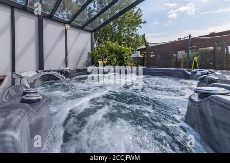 piscine extérieure moderne avec massages, boissons fraîches et vin Banque D'Images