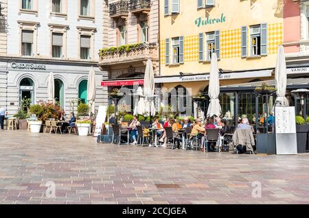 Lugano, Tessin, Suisse - 20 avril 2018 : les gens se détendent et apprécient le bar en plein air de la Piazza della Riforma, dans le centre historique de Lugano. Banque D'Images