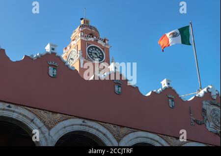 Centre culturel Olimpo avec tour et drapeau soufflé sur ciel bleu sans nuages, Merida, Yucatan, Mexique Banque D'Images