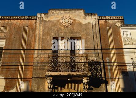 Façade abandonnée de la maison coloniale avec stuc et balcon éclairé par le soleil, Merida, Yucatan, Mexique Banque D'Images