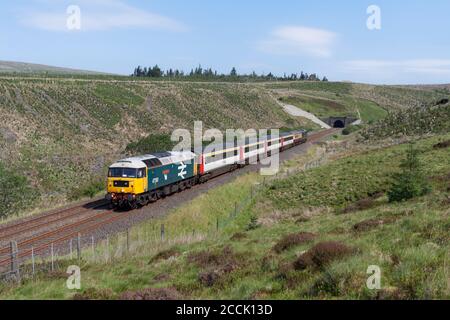 Le train « The Staycation Express » quitte le tunnel de Rise Hill Le pittoresque s'installe à Carlisle ligne de chemin de fer en classe 47 locomotive 47593 Banque D'Images