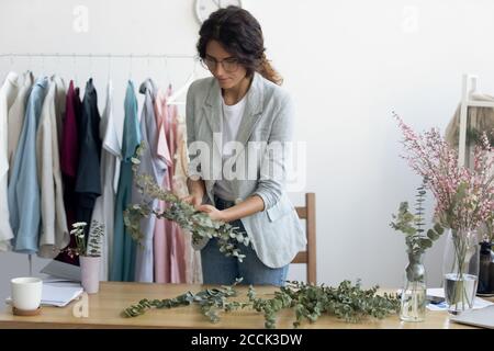 Jeune fleuriste créative de sexe féminin qui fait de la composition de plantes vertes. Banque D'Images