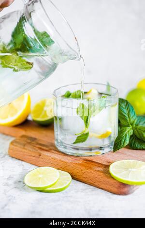 Détox eau avec citron, lime et menthe et glaçons Banque D'Images