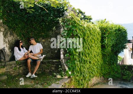 Jeune couple amoureux assis sur le banc, Bellagio, Italie Banque D'Images