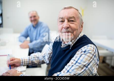 Homme âgé suivant un cours d'éducation pour les aînés Banque D'Images