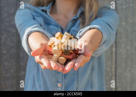 Femme tenant un puzzle en bois dans ses mains Banque D'Images