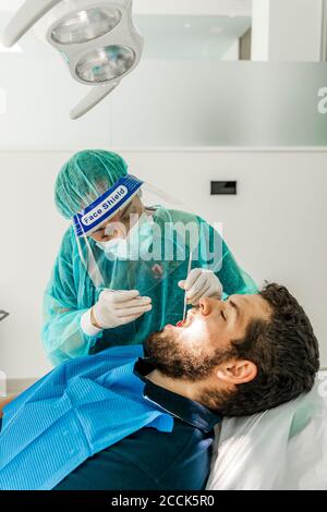 Infirmière de sexe féminin qui examine le patient dans la clinique du dentiste Banque D'Images