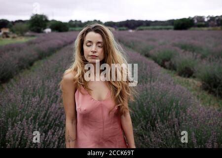 Woman standing in lavender field Banque D'Images