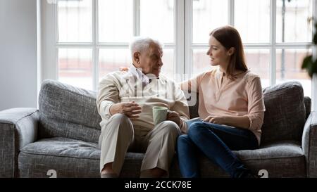 Homme âgé souriant des années 80 parlant à une fille adulte. Banque D'Images