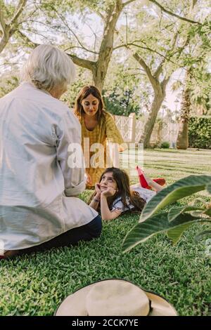 Famille de plusieurs générations se détendant sur des terres herbeuses dans la cour Banque D'Images