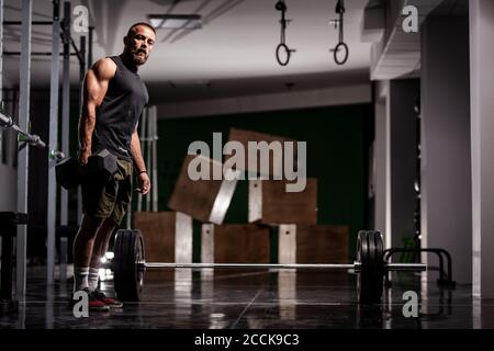 Athlète musclé se préparant à l'haltérophilie. Entraîneur CrossFit dans un studio de fitness. Banque D'Images