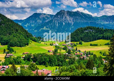 Allemagne, Bavière, Tiefenbach, village rural dans les Alpes d'Allgau avec Entschenkopf et Rubihorn en arrière-plan Banque D'Images