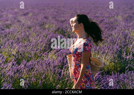 Portrait de la belle femme debout dans un vaste champ de lavande avec main dans les cheveux Banque D'Images