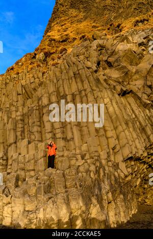 Femme prenant une photo à la plage de Reynisfjara, Islande Banque D'Images