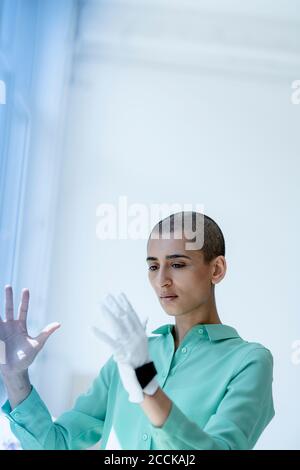 Portrait d'une femme ciblée avec des cheveux courts portant des gants Banque D'Images