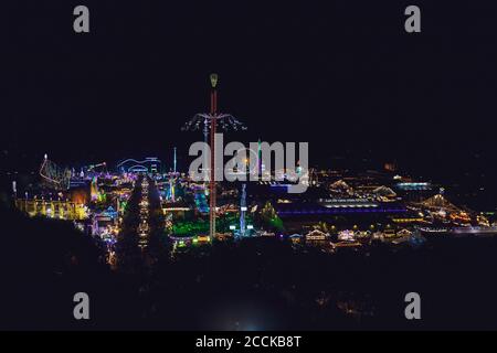 Allemagne, Bavière, Munich, Drone vue sur le parc d'attractions illuminé pendant l'Oktoberfest la nuit Banque D'Images