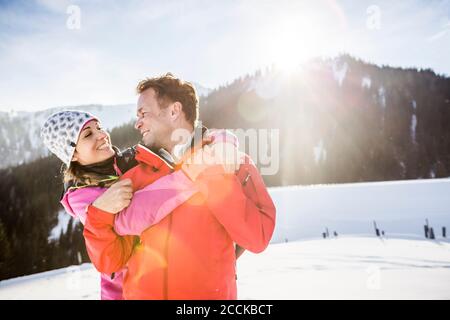 Couple enchâssant dans un paysage de montagne enneigé, Achenkirch, Autriche Banque D'Images